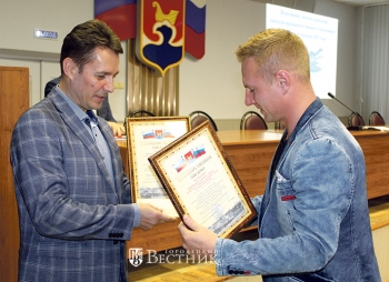 Первый заместитель главы администрации Городецкого муниципального округа А.В. Сатанов награждает К.Н. Романова