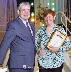 Н.Ф. Поляков вручает награду оператору машинного доения коров Н.М. Малышевой (колхоз-племзавод им. Куйбышева).